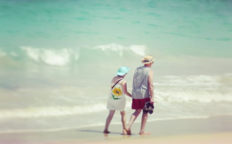 浜辺で散歩している老夫婦